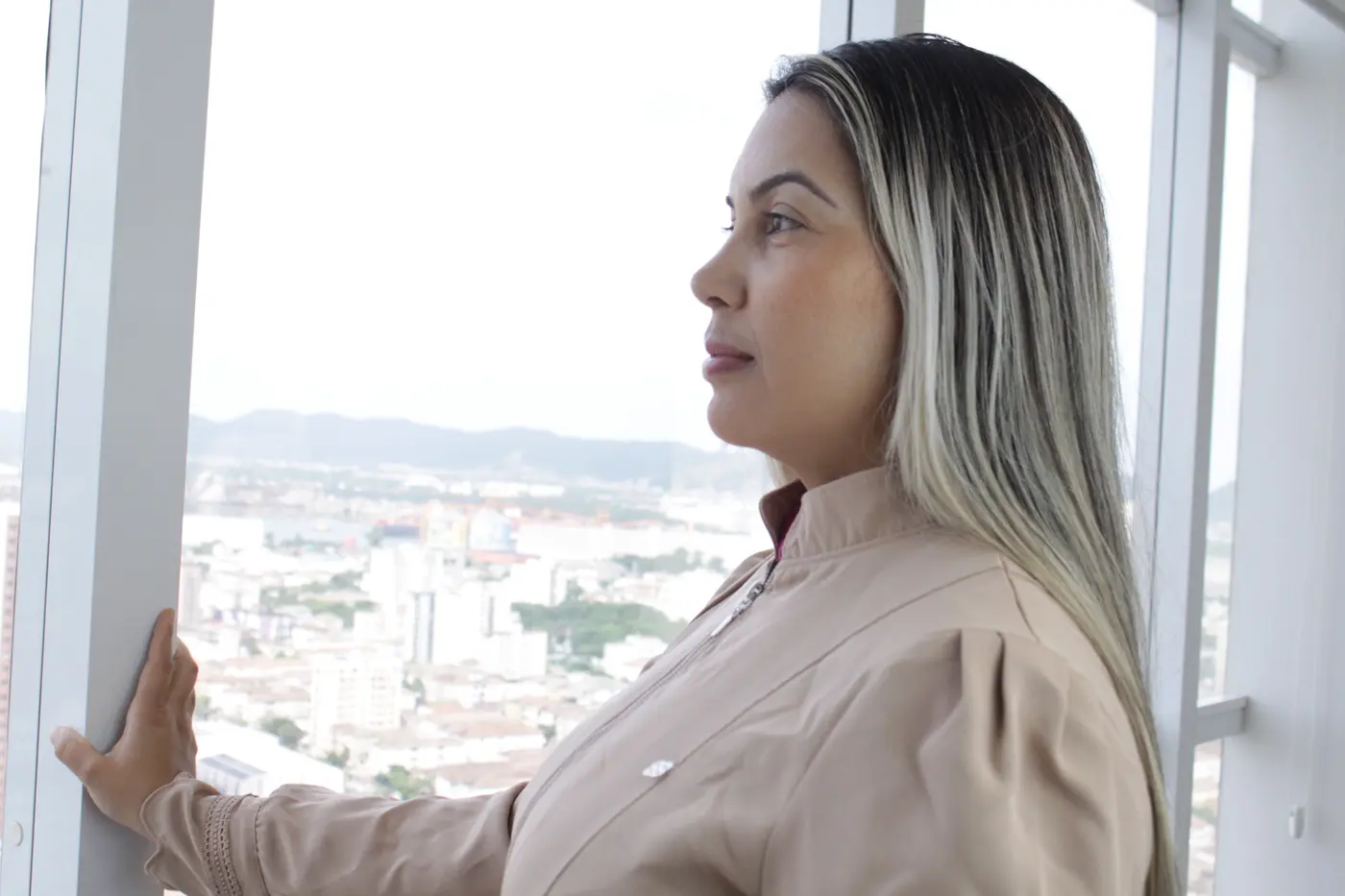 Dra. Joalla Rocha contemplando a vista de Santos na clínica